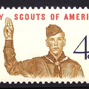 May include: A vintage 4-cent US postage stamp featuring a Boy Scout in uniform, saluting with his right hand. The stamp is from 1960 and has the text "BOY SCOUTS OF AMERICA" in red and "U.S. POSTAGE" in blue.