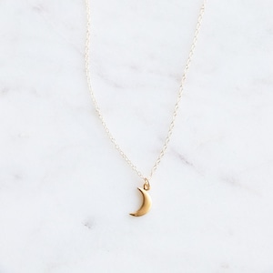 This dainty little gold moon charm dangles on an 18 inch 14k gold filled chain. Choose another tiny charm necklace in your favorite style if you like: mountains, heart, or puzzle.