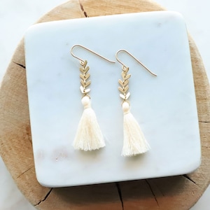 Cream off white Tassels hang from about 3/4 of an inch of brushed gold chevron chain. Ear wires are natural brass. Lots of color choices available.