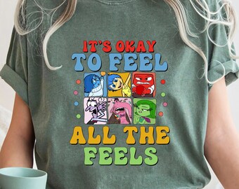 Könnte beinhalten: Grünes T-Shirt mit einem Vintage-Grafikdruck mit den Figuren aus dem Film Inside Out. Der Text lautet "Es ist okay, alle Gefühle zu fühlen."