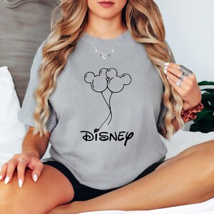 Może przedstawiać: Szary T-shirt z czarnym nadrukiem przedstawiającym balony w kształcie uszu Myszki Miki i napisem "DISNEY" poniżej.