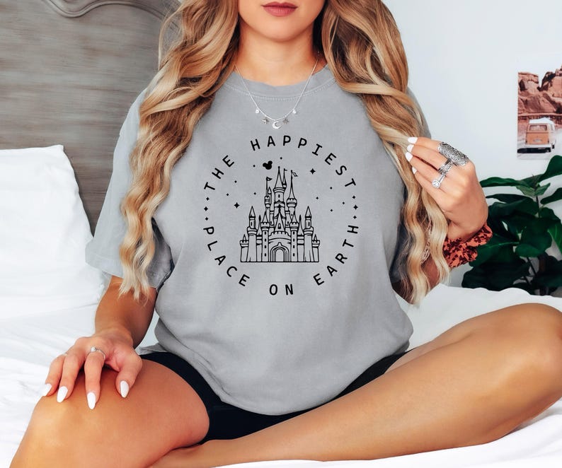 May include: A gray t-shirt with a black graphic of Cinderella's castle and the text "The Happiest Place On Earth".