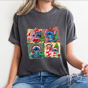 Puede incluir: Una camiseta gris oscuro con un gr&aacute;fico navide&ntilde;o con Stitch y Angel de la pel&iacute;cula de Disney Lilo & Stitch. El gr&aacute;fico muestra a Stitch y Angel con gorros de Pap&aacute; Noel y sosteniendo regalos de Navidad.