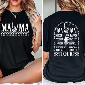 May include: Black graphic tee with the text "MAMA" and a skeleton hand gesture. The shirt also says "THE MOTHERHOOD TOUR" and lists various activities. The back of the shirt has the text "SOME DAYS I ROCK IT, SOME DAYS IT ROCKS ME. EITHER WAY WE'RE ROCKIN".