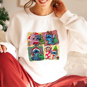 Puede incluir: Sudadera blanca con un estampado gr&aacute;fico colorido de cuatro personajes de Stitch de la pel&iacute;cula de Disney Lilo & Stitch. Los personajes llevan gorros de Pap&aacute; Noel y sostienen &aacute;rboles de Navidad y bastones de caramelo. El texto "White" es visible en la esquina superior izquierda de la imagen.