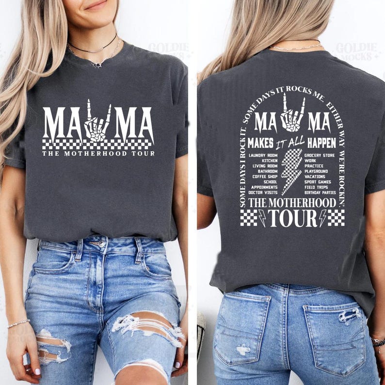 May include: Dark gray t-shirt with the text "MAMA" in white, featuring a skeleton hand gesture. The front reads "THE MOTHERHOOD TOUR." The back of the shirt says "MAMA MAKES IT ALL HAPPEN" with a list of activities.