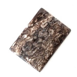 May include: A rectangular slab of polished brown and white agate with a swirling pattern.
