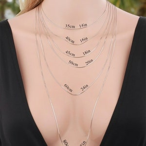 Peut inclure: Une mannequin porte un collier en cha&icirc;ne argent&eacute;e de diff&eacute;rentes longueurs, avec des mesures en pouces et en centim&egrave;tres. Les longueurs sont de 14 pouces (35 cm), 16 pouces (40 cm), 18 pouces (45 cm), 20 pouces (50 cm), 24 pouces (60 cm) et 32 pouces (80 cm).