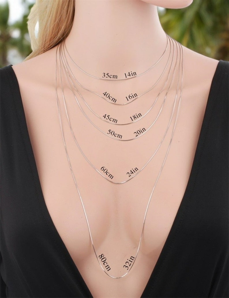 Peut inclure: Une mannequin porte un collier en cha&icirc;ne argent&eacute;e de diff&eacute;rentes longueurs, avec des mesures en pouces et en centim&egrave;tres. Les longueurs sont de 14 pouces (35 cm), 16 pouces (40 cm), 18 pouces (45 cm), 20 pouces (50 cm), 24 pouces (60 cm) et 32 pouces (80 cm).