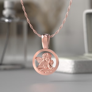 Peut inclure: Un collier en or rose avec un pendentif repr&eacute;sentant un ange ch&eacute;rubin avec des ailes dans un cadre circulaire.