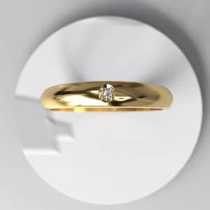 May include: A simple gold band ring with a single small diamond set in the centre.