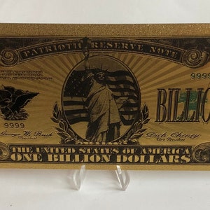 Peut inclure: Un billet de banque en papier de couleur dorée avec le texte "PATRIOTIC RESERVE NOTE" et "ONE BILLION DOLLARS" imprimé dessus. Le billet présente une image en noir et blanc de la Statue de la Liberté et le texte "9999 BILLION".
