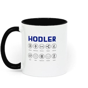 May include: White ceramic coffee mug with a black rim and handle. The mug has the word "HODLER" printed in blue letters and a variety of cryptocurrency logos in grey.
