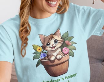 May include: Light blue t-shirt featuring a cartoon kitten in a brown flower pot with colorful flowers and green leaves. The text "Gardener's Helper Kitty Cat" is printed below the image.