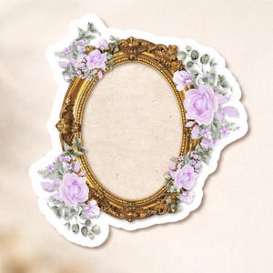 Puede incluir: Una pegatina de marco ovalado dorado con detalles ornamentados, adornada con rosas de color púrpura claro y follaje verde. La pegatina tiene un borde blanco y una estética vintage, ideal para álbumes de recortes o proyectos de manualidades.