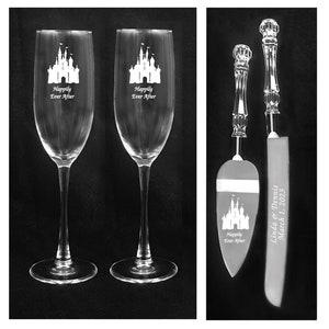 May include: A wedding cake serving set with two champagne flutes and a cake knife. The flutes and knife are engraved with a castle and the text "Happily Ever After". The cake knife also has the text "Linda & Dennis March 1, 2023" engraved on it.