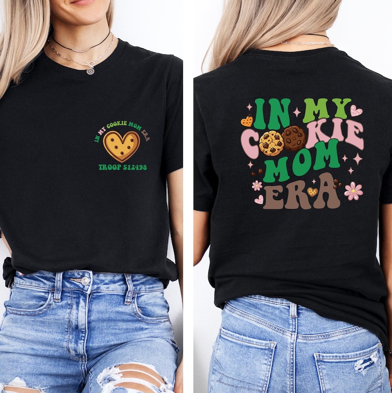 a woman wearing a black t-shirt with a graphic design on the back. The design includes a heart-shaped cookie and the text "In my cookie mom era" along with other cookie-related imagery.