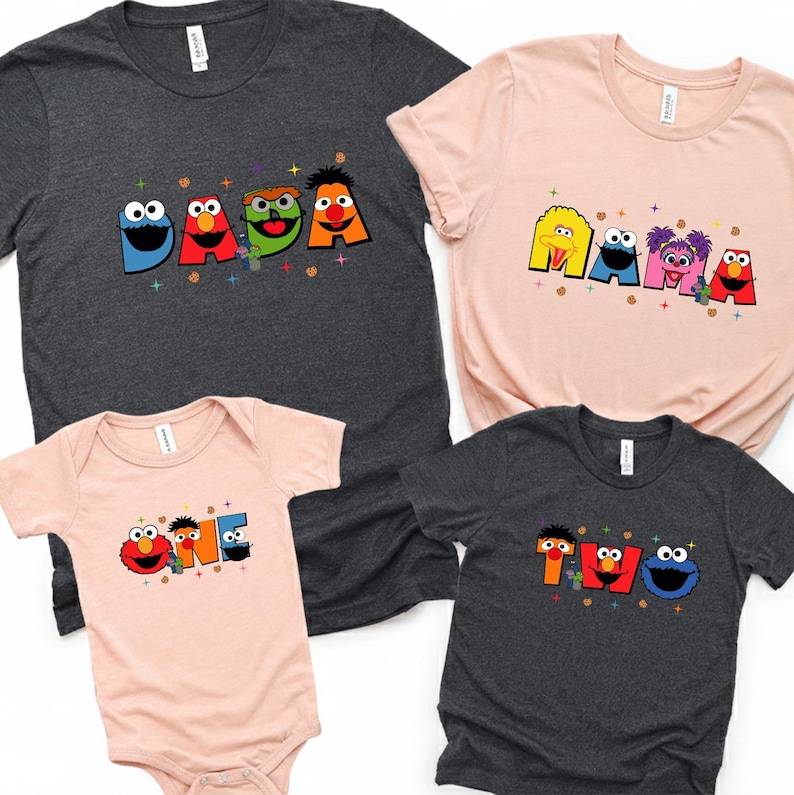four t-shirts, each featuring a different character from the Sesame Street cartoon series. The characters are arranged in a row, with the largest character on the left and the smallest on the right. The t-shirts are designed to be personalized with the characters' names, likely for a family or a group of friends.