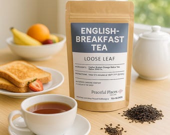 May include: A package of English Breakfast loose leaf tea with a blue and white label. A white teacup and saucer, a teapot, and a plate of toast and fruit are also visible. The text on the package reads "Peaceful Places Tea Blends."