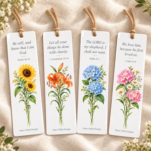 May include: Four rectangular white bookmarks with jute twine tassels, each featuring a floral illustration and a Bible verse. The designs include sunflowers with Psalm 46:10, orange lilies with 1 Corinthians 16:14, blue hydrangeas with Psalm 23:1, and pink hydrangeas with 1 John 4:19. Each bookmark is labeled Peace Filled Designs.