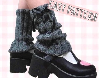 May include: Gray knitted leg warmers with a black ribbon tie. The leg warmers are worn over black platform shoes with a white toe and a pink heart detail. The text "EASY PATTERN" is written in pink on a white background.