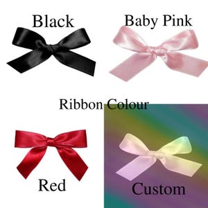 May include: Four different ribbon colors are shown in the image. The colors are black, baby pink, red, and custom. The ribbon is tied in a bow.