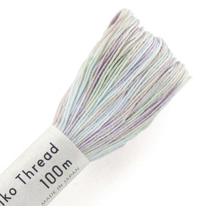 May include: A skein of pale blue, green, and purple embroidery floss. The floss is wound around a white cardboard spool with the text "Iko Thread 1000m Made in Japan".