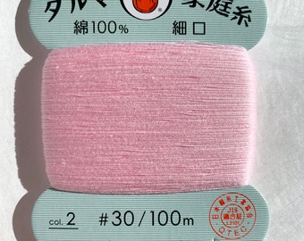May include: A spool of pink cotton thread labeled "Daruma" with the text "#30/100m" and "daruma-ito.co.jp". The label also states "Made in Japan" and "Cotton 100%".