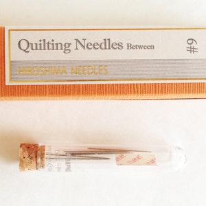 Puede incluir: Un paquete de agujas para acolchar Tulip en un tubo de vidrio. Las agujas son del tama&ntilde;o #9 y est&aacute;n hechas en Jap&oacute;n. El embalaje es naranja y blanco con el texto "Quilting Needles Between Hiroshima Needles".