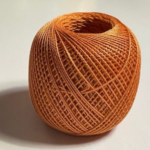 May include: A ball of orange embroidery floss.