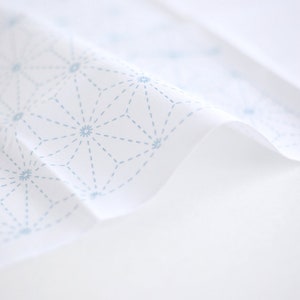 Puede incluir: Tela blanca con un patr&oacute;n repetitivo de estrellas azules conectadas por l&iacute;neas finas.