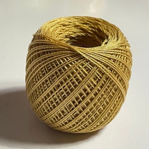 May include: A ball of golden yellow embroidery floss.