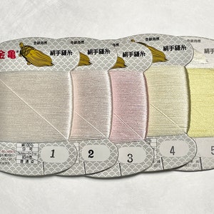 May include: Five spools of silk thread in varying pastel colors, labeled 1 through 5. The spools are on a white background. Each spool has a label with Japanese text and a gold turtle logo.