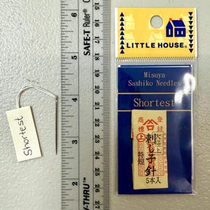 Pu&ograve; includere: Un pacchetto di aghi Sashiko Misuya etichettato "Shortest" in una confezione blu e bianca con il testo "Little House" sul davanti. Il pacchetto contiene 5 aghi ed &egrave; etichettato in giapponese.