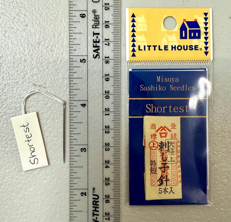 Pu&ograve; includere: Un pacchetto di aghi Sashiko Misuya etichettato "Shortest" in una confezione blu e bianca con il testo "Little House" sul davanti. Il pacchetto contiene 5 aghi ed &egrave; etichettato in giapponese.