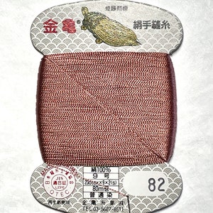 May include: A spool of brown silk thread with a label that reads "絹100% 9号 236tex×9×2(s) 80m巻 普通染 金亀糸業 株式会社 TEL 03-5687-8511" and "網手縫糸 82".