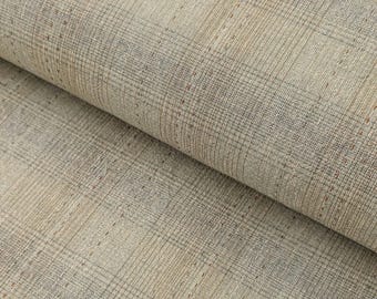 May include: Close-up of a folded fabric with a plaid pattern. The fabric has a neutral color palette with beige, tan, and gray tones. The weave is visible, creating a textured appearance. The plaid design is formed by intersecting lines.