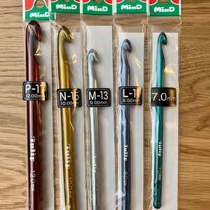 May include: Five Tulip Mind crochet hooks in different sizes and colors. The hooks are packaged individually and labeled with the size and length in millimeters. The sizes are P-17 (12.00 mm), N-16 (10.00 mm), M-13 (9.00 mm), L-11 (8.00 mm), and 7.0 mm.