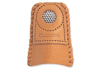 May include: A tan leather thimble with a metal mesh top and the word "CLOVER" embossed on the front.