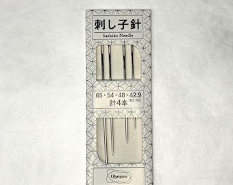 Puede incluir: Un paquete de agujas Sashiko Olympus. El paquete blanco presenta texto negro, incluyendo "Sashiko Needle" y tamaños de aguja en milímetros. El paquete contiene cuatro agujas de diferentes longitudes, ideales para bordado Sashiko.