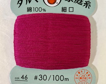 May include: A spool of #30/100m  pink cotton thread, labeled "Daruma" and "Family Thread" in Japanese. The label also states "100% cotton" and "Fine Mouth".