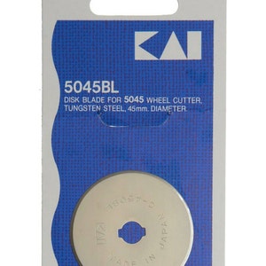 May include: A silver Kai 5045BL disc blade for a wheel cutter. The blade is 45mm in diameter and made in Japan. The packaging is blue and white with the Kai logo.