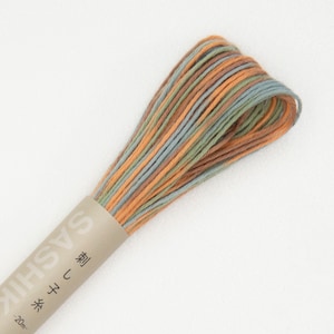 May include: A spool of Sashiko thread in a multi-colored pattern of orange, green, and blue. The label on the spool reads "Sashiko" and "20m" in Japanese.