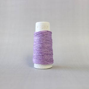 May include: A spool of purple thread with a white label that says "cosmo" on it.