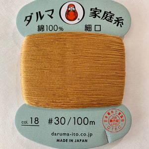 May include: A spool of #30/100m gold embroidery thread, made in Japan by Daruma Ito. The label reads "Daruma Family Thread, 100% Cotton, Fine Mouth".