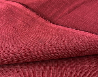 May include: Close-up of a textured, deep red fabric. The material is folded, revealing the weave and texture of the cloth. The color is a rich, saturated shade of red, with subtle variations in tone.