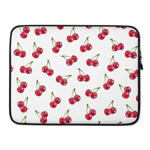 May include: A white laptop sleeve with a repeating pattern of red cherries on a white background.