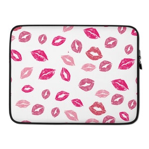 Könnte beinhalten: Eine weiße Laptoptasche mit einem sich wiederholenden Muster aus rosa und roten Lippenstift-Abdrücken.