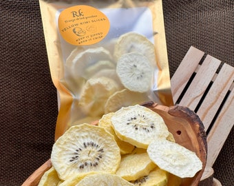 May include: A wooden bowl filled with dried yellow kiwi slices. The kiwi slices are arranged in a circular pattern and have a light yellow color. The bowl is made of light brown wood and has a smooth surface. The kiwi slices are a healthy and delicious snack.