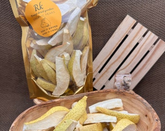 May include: A bag of freeze-dried organic pear slices. The bag is gold with a white label that says "Rk Freeze dried goodies ORGANIC PEARS KEEP IT ZIPPED KEEP IT CRISP". The pear slices are in a wooden bowl.